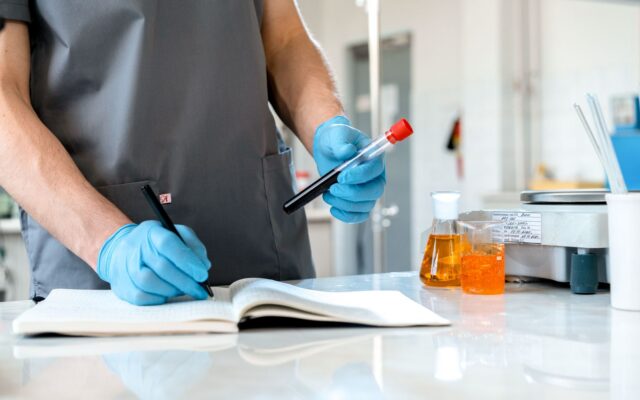 Researcher recording lab observations in a notebook